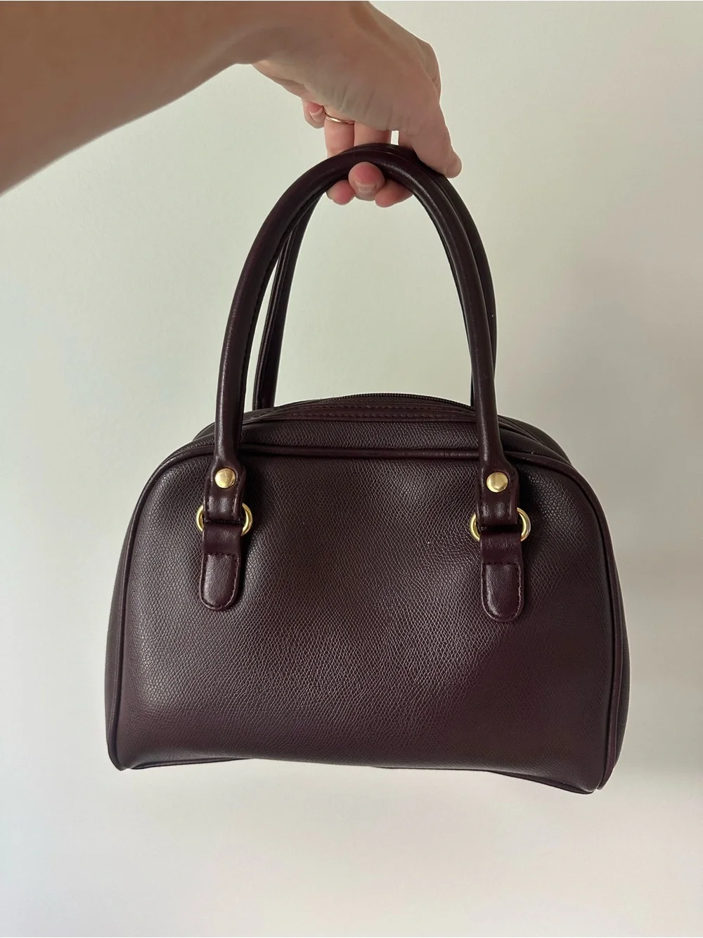 Vintage-inspired burgundy/oxblood structured handbag with gold accents